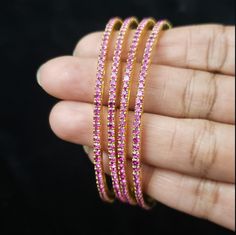 "* Handcrafted Gold Plated CZ Bangle Set * High Quality 22 K Gold Plated 4 pc bangle set; * 2.4 inches= ( 2.25\" diameter of the inner circle) ; 2.6 inches = ( 2.40\" diameter of the inner circle); 2.8inches = (2.54\" diameter of the inner circle) * Sold as a set of 4 bangles Gorgeous gold-plated bangle/ bracelet best exemplifies the careful craftsmanship done on it -- a specialty at Nemali Jewelry. It has special tone of elegance attached to it. The intricate handmade design of the bangle / bra Pink Stackable Wedding Bangle, Traditional Pink Bangle For Gift, Elegant Pink Bangle For Festivals, Traditional Adjustable Pink Bangle, Pink Handmade Traditional Bangle, Pink Hand-set Bangle Jewelry, Bangles Indian, Bridal Bangles, Pink Bridal