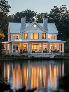 a large white house sitting on top of a lake