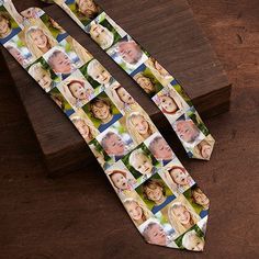 a neck tie that has pictures of people on it and is tied to a wooden block