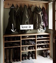 a coat rack filled with lots of coats and shoes next to a wooden door that says love it