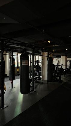 an empty gym with punching bags and equipment