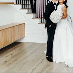 a bride and groom are standing in front of the stairs at their wedding reception venue