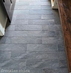 a kitchen with gray stone flooring and white cabinets