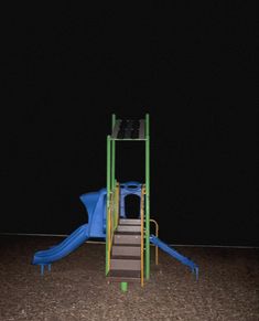 an empty playground at night with a slide