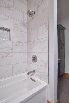 a white bath tub sitting next to a walk in shower