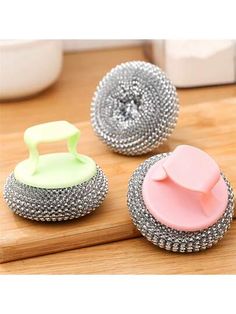 three different colored buttons sitting on top of a wooden table next to a knife and bowl