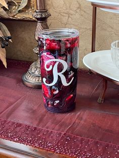 a red and white can with the letter r painted on it sitting on a table