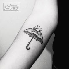 a black and white photo of a person with an umbrella tattoo on their arm,