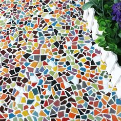 a vase filled with purple flowers sitting on top of a colorful tile covered flooring