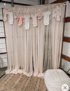 there are baby clothes hanging on the curtain