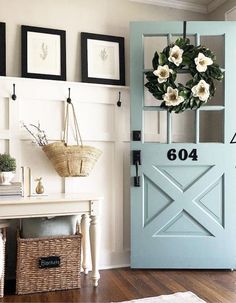 a blue front door with a wreath on it and some pictures hanging above the door