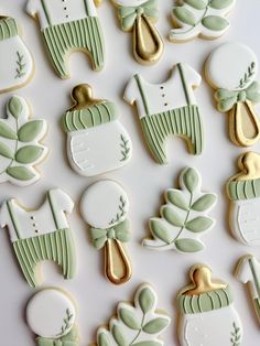 decorated cookies with green and gold accents on a white table top, including baby's first year ones