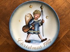 a ceramic plate with an angel holding a guitar and the words christmas 1932 on it