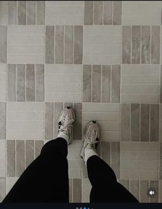 a person standing on a tile floor with their feet up in front of the camera