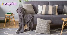 a living room filled with furniture and pillows on top of a gray carpeted floor