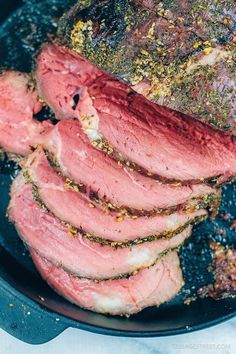 the steak is cooked in a skillet with spices and seasoning on top, next to a text overlay that reads perfectly cooked tender not tough low carb garlic & herb bottom round roast