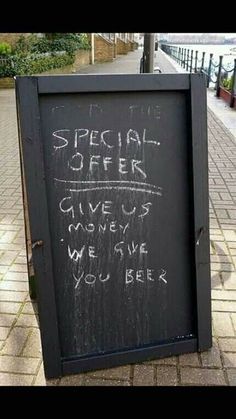 a sign that is on the side of a sidewalk with words written in chalk and writing underneath it