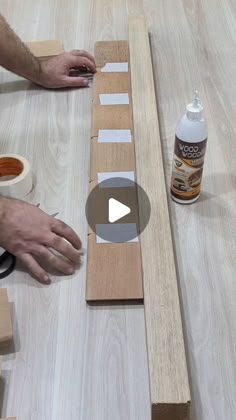 a person is working on some wood planks with glue and sanding paper next to it