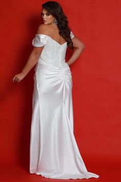 a woman in a white dress standing against a red background