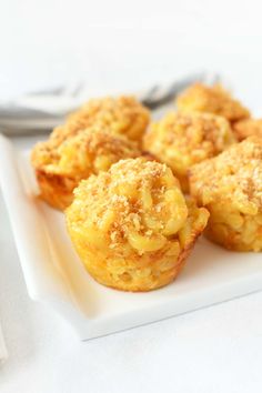 small muffins on a white plate next to a fork and napkin with utensils in the background