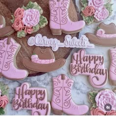 decorated cookies with cowboy boots and flowers on a table