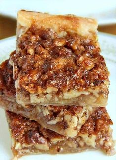 three pieces of pecan pie stacked on top of each other in a white plate