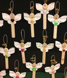 wooden pegs with angel decorations on them and music notes attached to the back of them