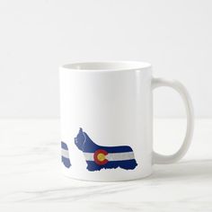 a white coffee mug with the state of colorado in blue, red, and white