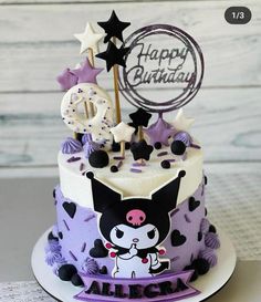 a purple and white birthday cake with an animal on it's top is shown