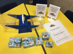 a toy airplane sitting on top of a table next to some dicers and cards