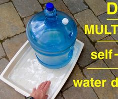 a large blue water bottle sitting on top of a white tray next to a hand