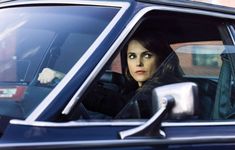 a woman sitting in the passenger seat of a car