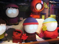 several cartoon figures are displayed in a display case at a store window with snow on the ground