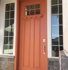 an orange front door with two windows