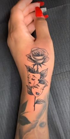 a woman's arm with a rose and a face tattoo on the left forearm