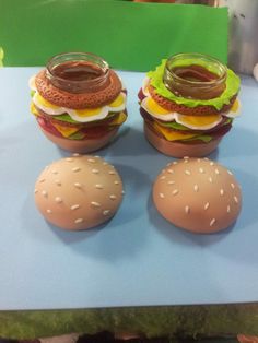 three hamburgers and two eggs sitting on a table next to each other with sauce in them