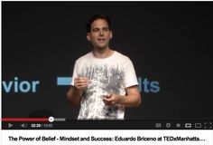 a man standing in front of a screen giving a speech on stage with the caption'the power of belfi - minds and success edward brucho