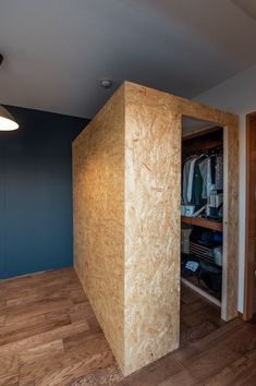 an empty closet in the middle of a room with wood floors and blue walls on either side