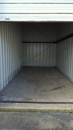 an empty storage unit with no doors on the outside and concrete flooring in front