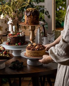 a table topped with cakes covered in frosting and toppings on top of wooden tables