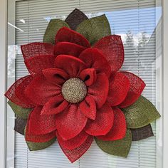 a red flower is hanging on the side of a window