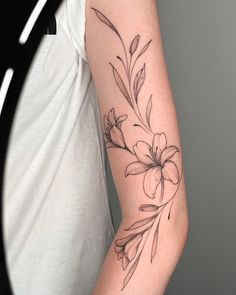 a woman's arm with a flower tattoo on the left side of her arm