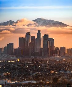 the city is surrounded by mountains and clouds