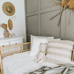 a teddy bear sitting on top of a bed next to pillows and blankets in a room