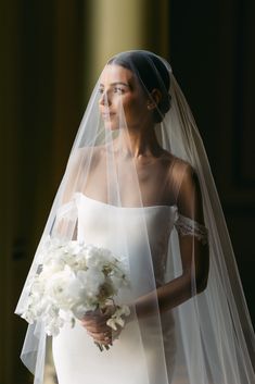 a woman in a wedding dress holding a bouquet