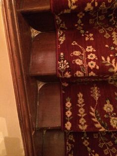 a close up view of a stair case with flowers and leaves on the carpeting