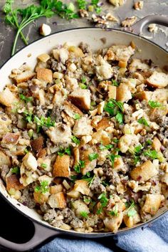 a pan filled with stuffing and vegetables on top of a table