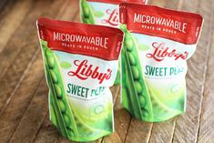 three bags of lippy sweet peas sitting on a wooden table next to each other