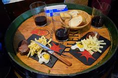 a wooden table topped with two trays filled with different types of food and drinks