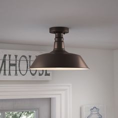 the light fixture is hanging from the ceiling in the kitchen, which also has an old - fashioned sign above it